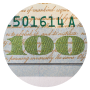 The number 100 in green in the bottom right corner of a $100 bill.